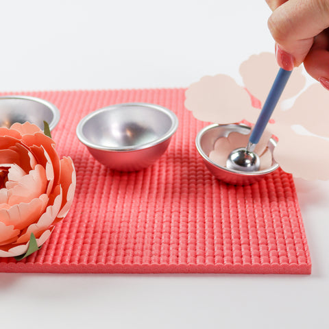 shaping pink paper peony using metal ball tool, metal shaping cups, and a coral shaping mat