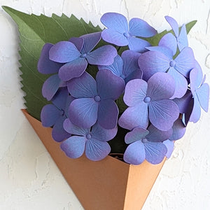 Blue purple paper hydrangea blossoms in a geometric wall planter