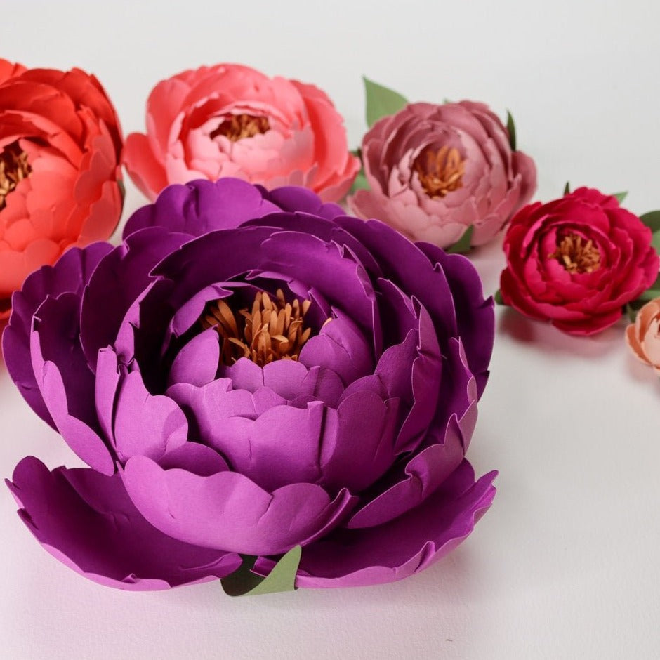 Violet paper peony surrounded by smaller pink paper peonies